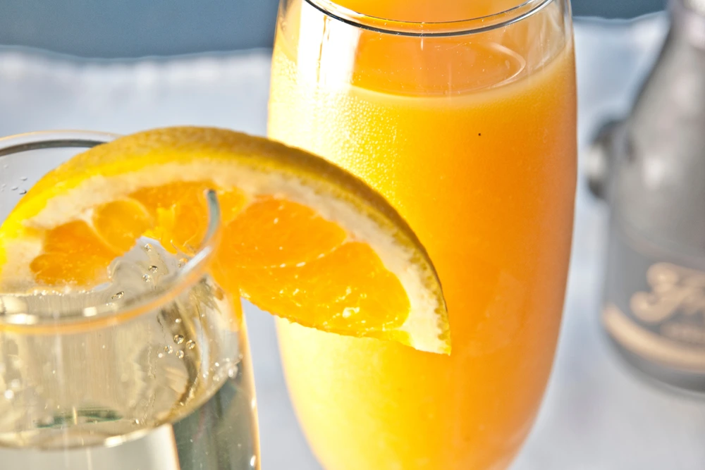 Champagne Mimosa Cocktail with orange wedge