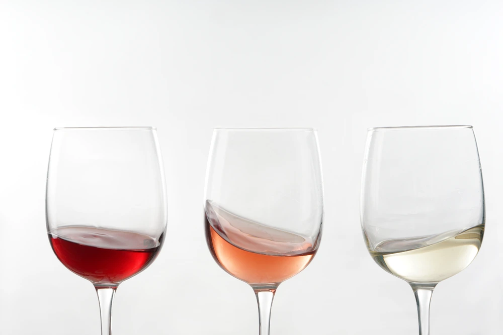 Red wine, Rose wine and white wine swirling in glasses