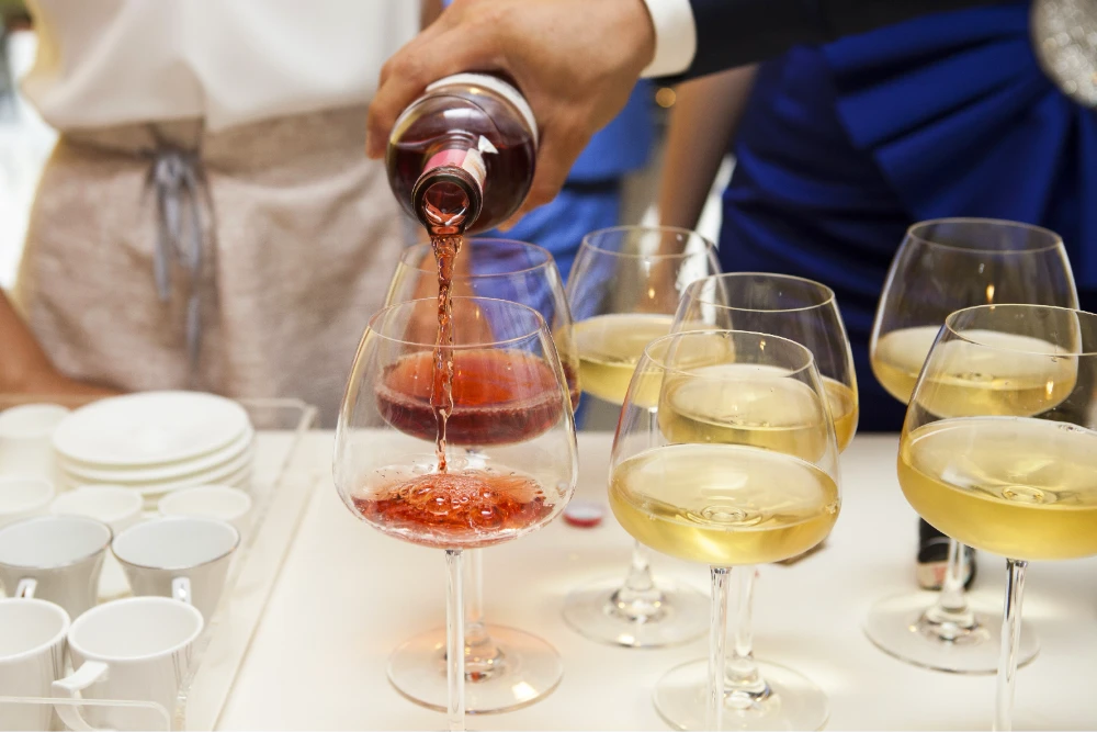Pouring red and white wine at a wine tasting
