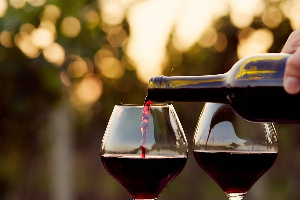 Pouring red blend wine into glasses outdoors