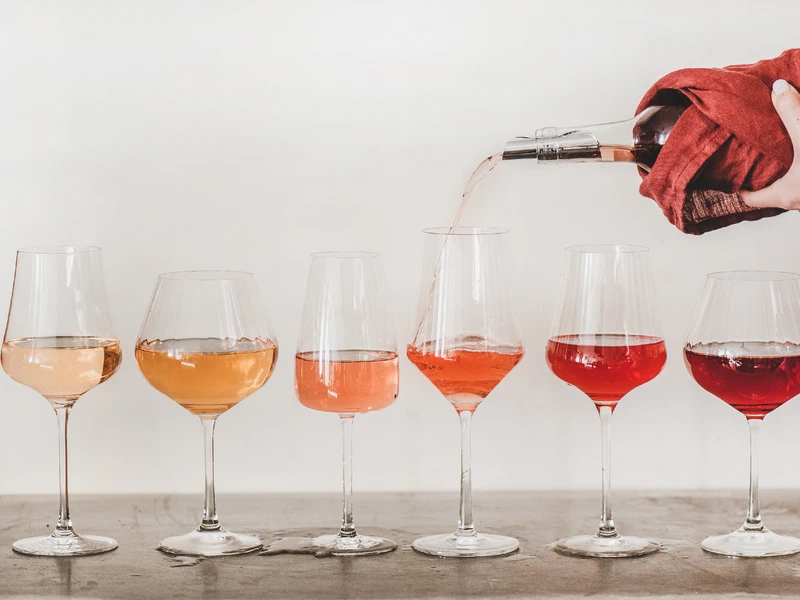 White Zinfandel and different roses lined up in glasses while being poured