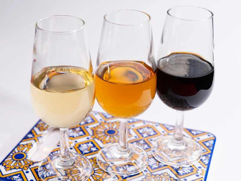 Different types of fortified wines in glasses on a drink coaster
