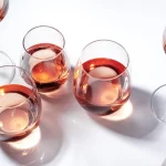 Rose wine of different shades in glasses on white background