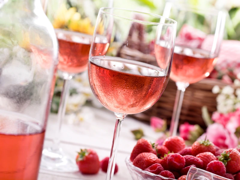 White Zinfandel in glasses with raspberries in a bowl