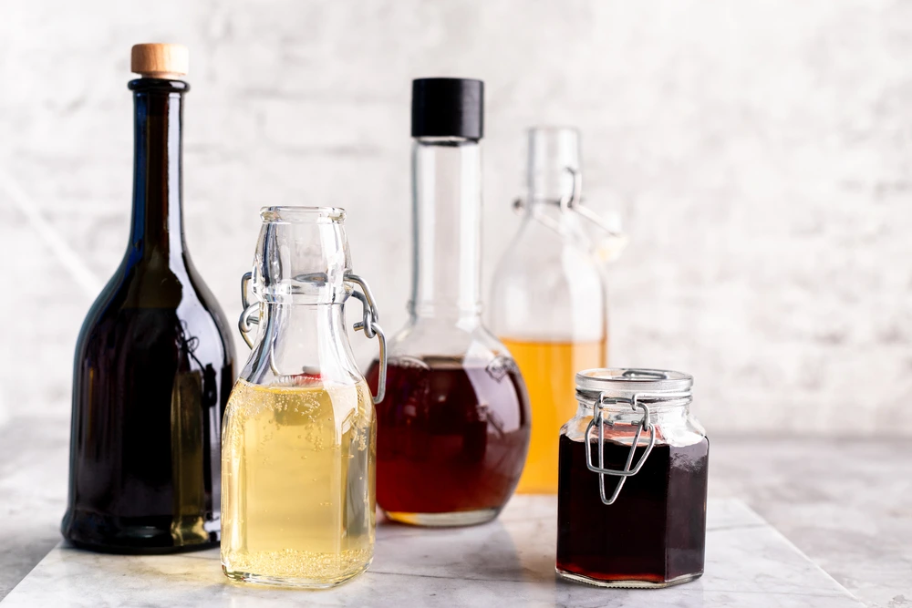 Different vinegar bottles lined up on a white background