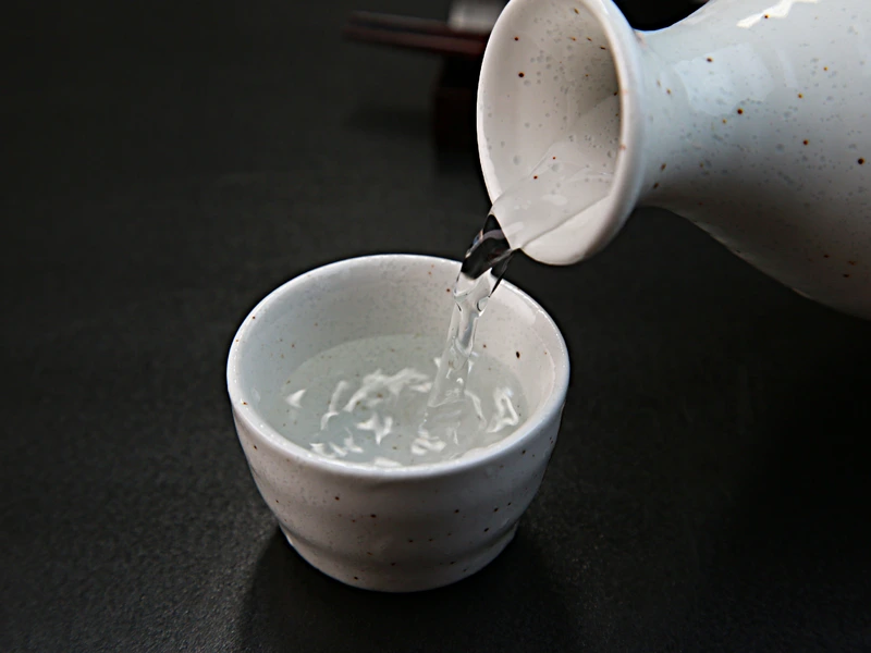 Rice wine being poured into a saucepan