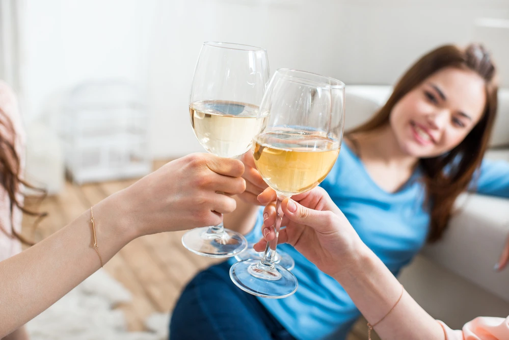 Women cheersing with different white wines