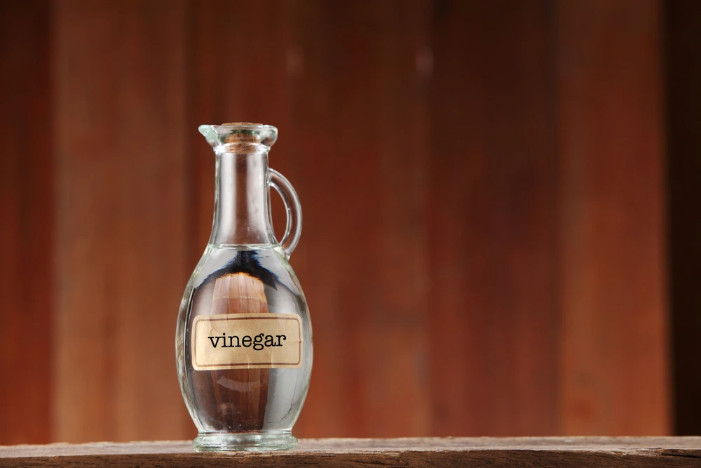 White vinegar in a bottle with label with a blurred background