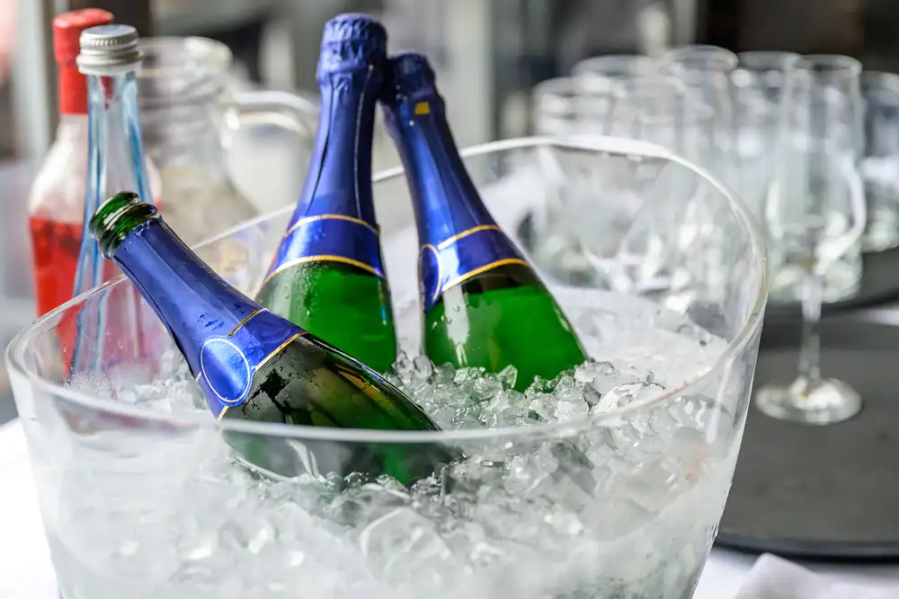 Champagne bottles bathing in a bucket of ice on a table
