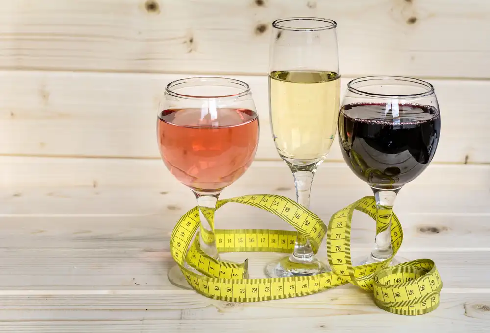 Various wines in different glasses with tape measure wrapped around glass stem
