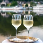 Glasses of Riesling on an outdoor patio beside a river in Germany